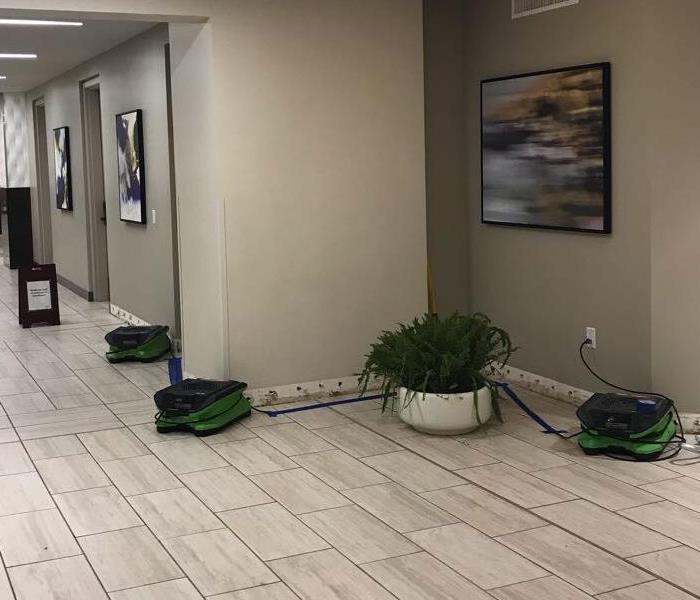 Lobby area with three green air movers. 