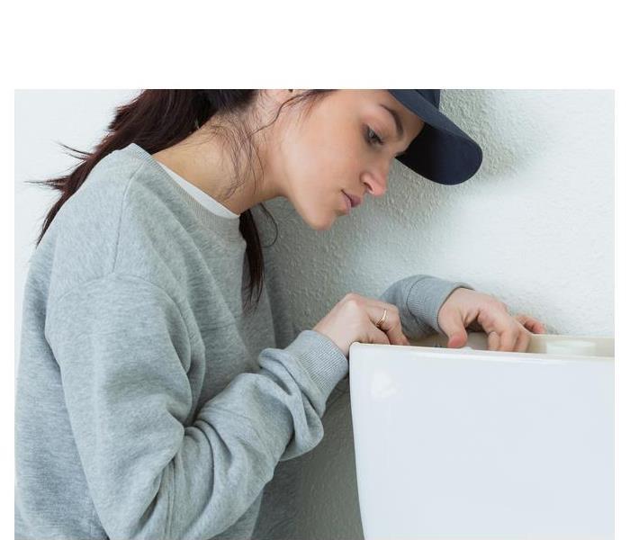 female fixing a toilet