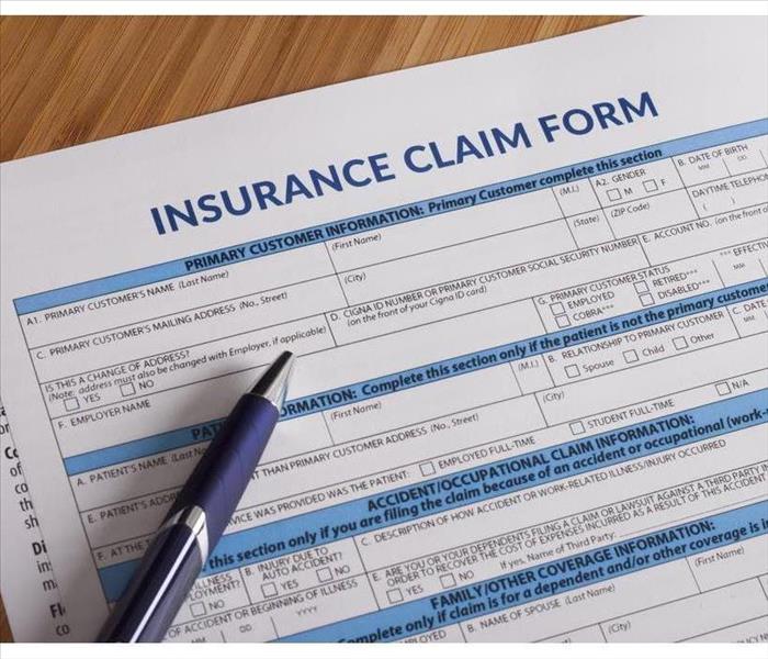 A sheet of an insurance claim for and a pen