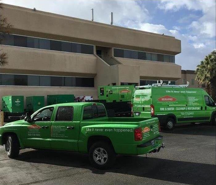 SERVPRO pick up truck a van and generator on parking lot ready to perform restoration services at a commercial building